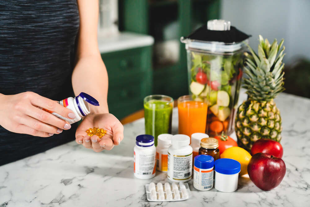 woman taking food supplements instead of fresh fru 2023 11 27 05 03 22 utc